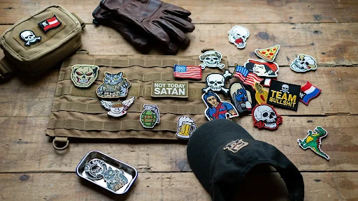 custom morale patches placed on a wooden table with tactical gear.